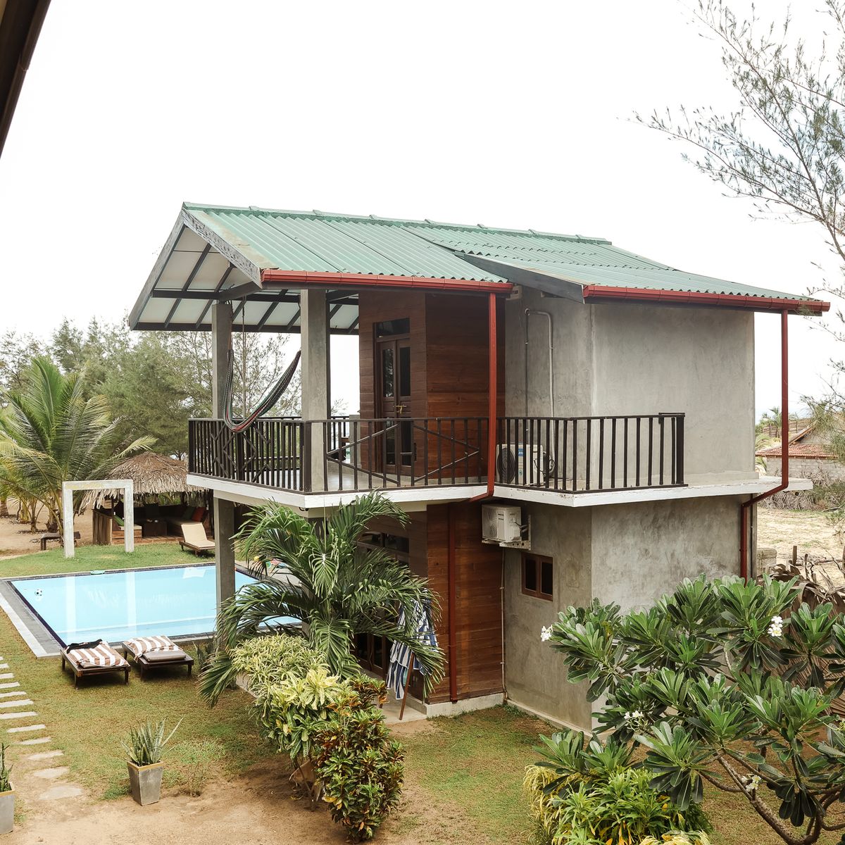Zweistöckige Holz-Cabana mit Balkon und Pool im Garten des Stay Golden in Arugam Bay